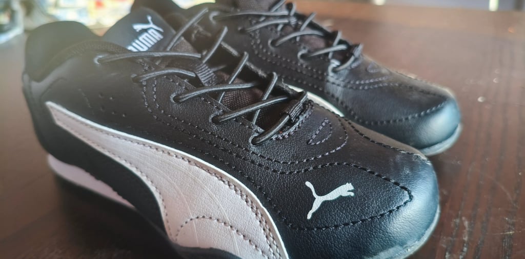Sapatilhas infantis Puma Catch pretas com velcro e logo Puma em branco vistas de frente