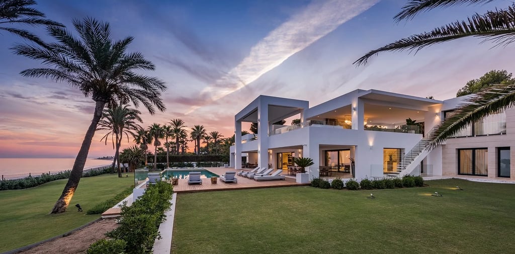 Contemporary beachfront villa at sunset with infinity pool and palm lined gardens