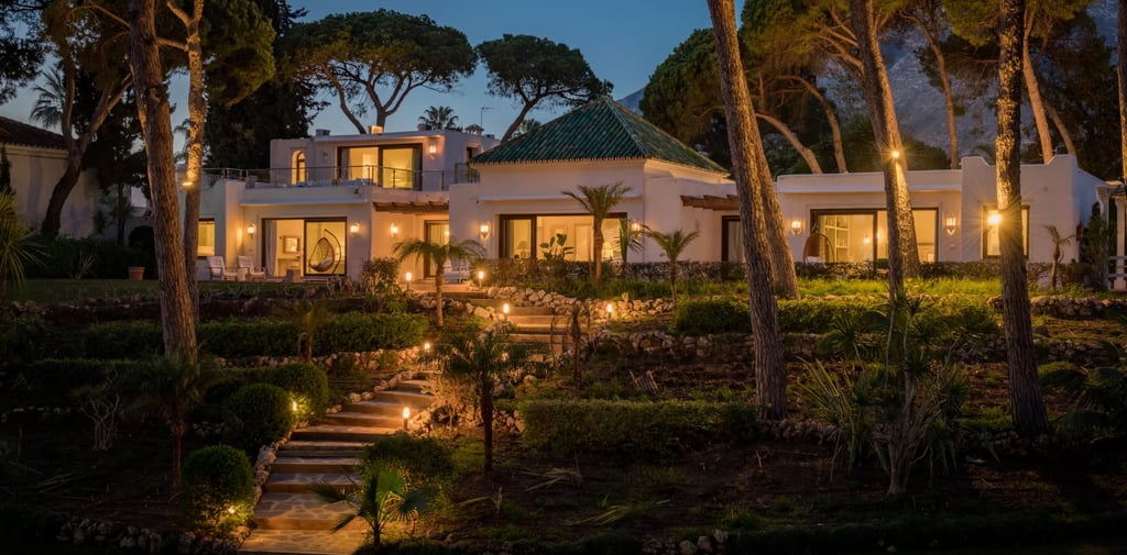 Evening exterior view with landscaped gardens and illuminated façade