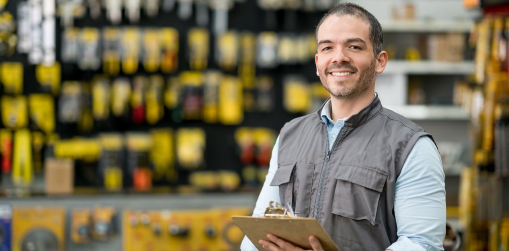Local business owner in a hardware store holding a clipboard, representing service-based niches for 