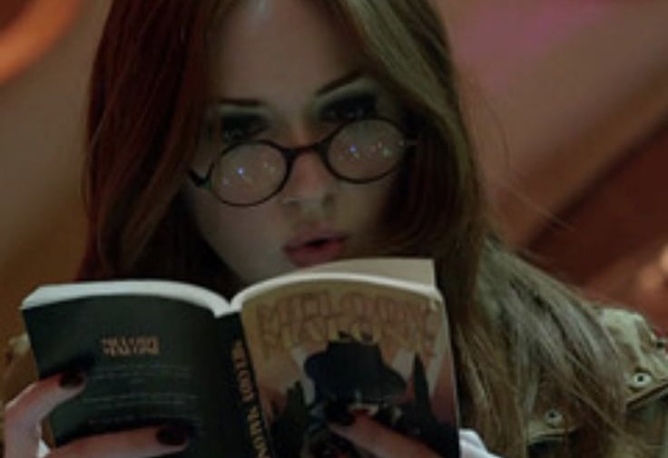 imagem da personagem amy pond da serie doctor who lendo um livro dentro da tardis