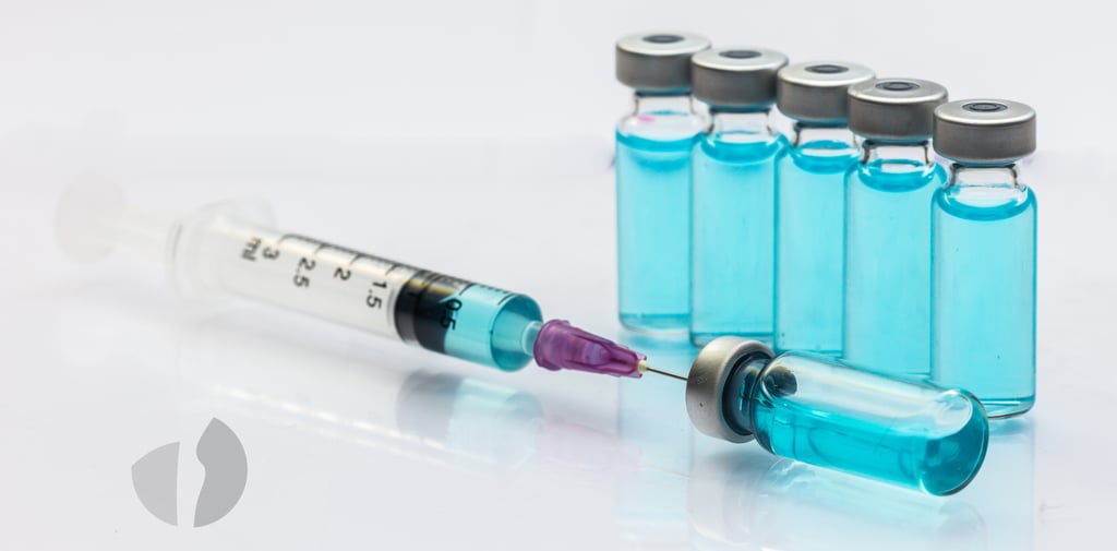 Seringa com agulha e frascos de liquido azul