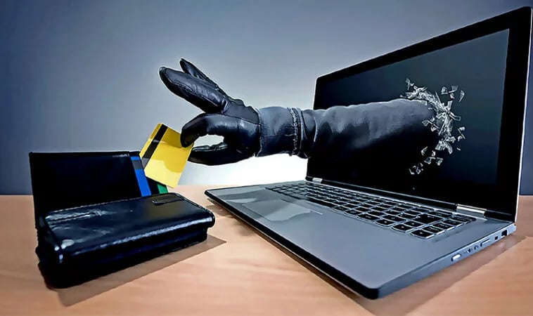imagem ilustrativa de uma mão saindo da tela do computador roubando o cartão da bolsa 