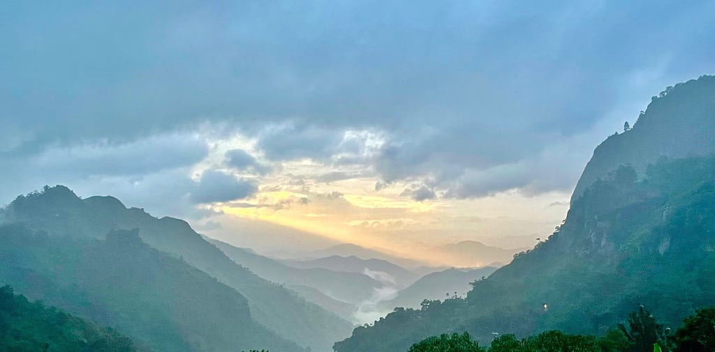 a mountain view of a valley with a sunset