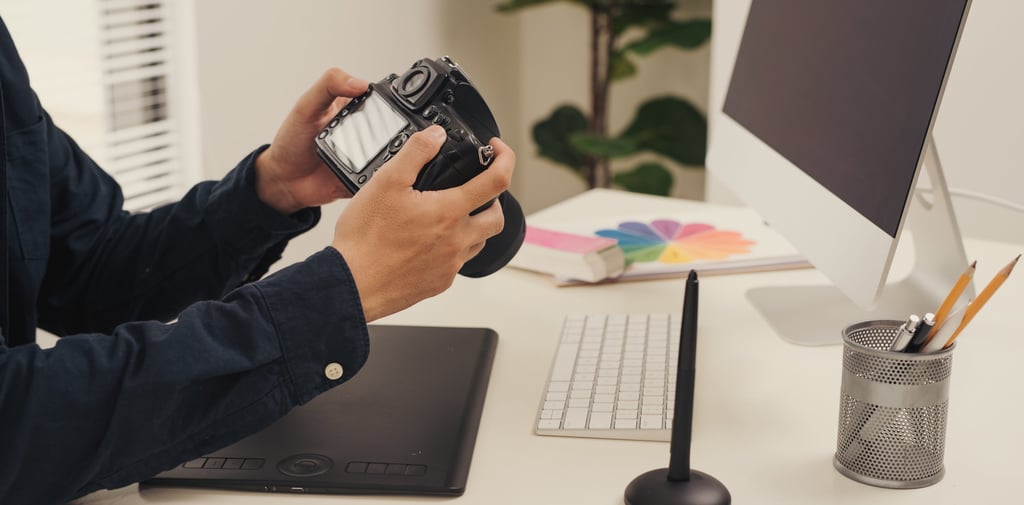 a man sitting at a desk with a camera ready to design