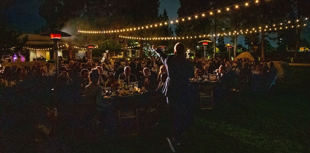 a man standing in front of a crowd of people fundraising event planner
