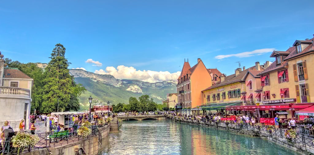 an image of colorful houses by the river overlooking a green mountain