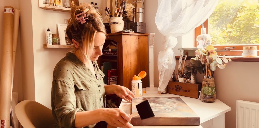 Applying the final layer of varnish to a painting