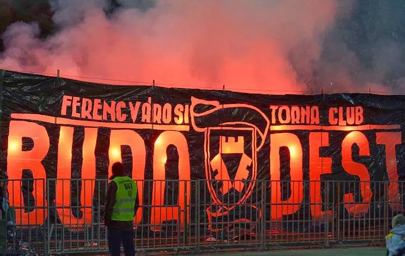 Ferencvárosi TC-Fans im Stadion der Groupama Aréna, jubelnd mit Vereinsfarben und Fahnen, während sie ihre Mannschaft lautsta