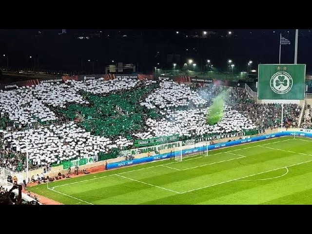 Innenaufnahme des GSP Stadium in Nikosia während eines Spiels von Omonia Nikosia, volle Tribünen mit jubelnden Fans und grün-