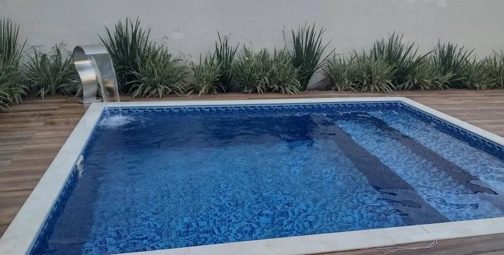 Kolam renang kecil dengan lapisan keramik mozaik biru yang elegan.