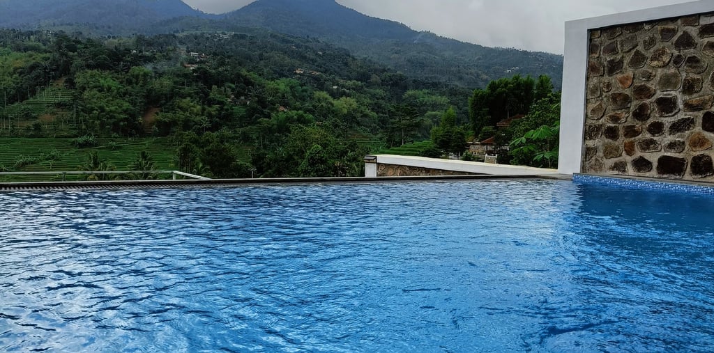 Kolam infinity di tebing dengan pemandangan laut lepas.