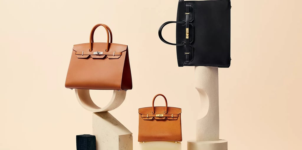 Hermes Birkin bags, Luxury tan and black handbags displayed on minimalist stone stands.