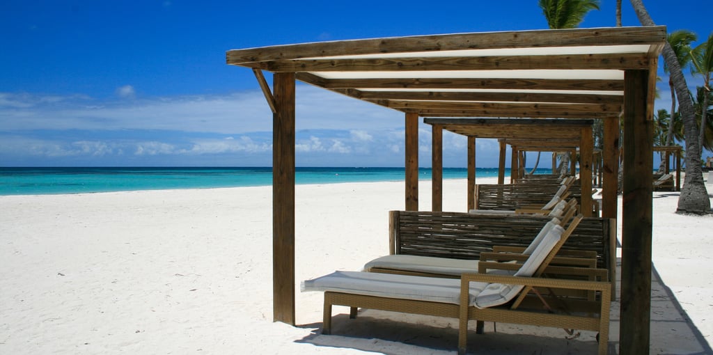 a beach with lounge chairs in cap cana