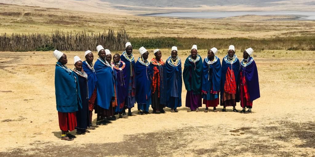 A group of Maasai women standing in semi circle.