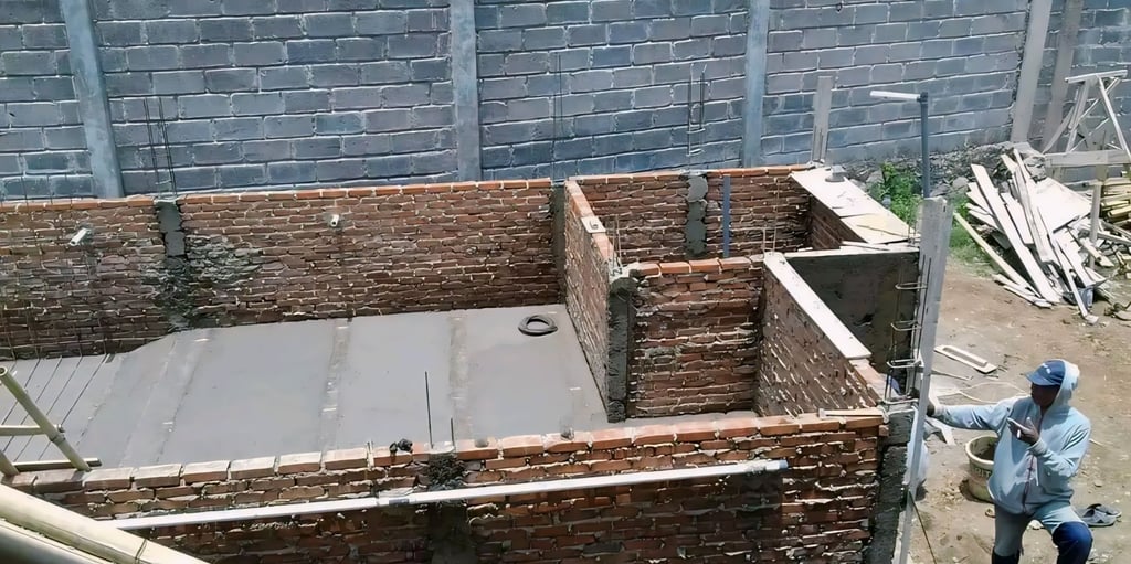 proses pembuatan kolam renang dengan bata merah sebagai penahan beton bagian luar.