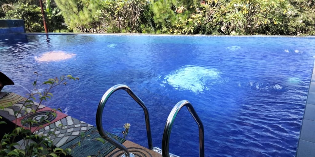 kolam renang minimalis dengan keramik berwarna biru tua.