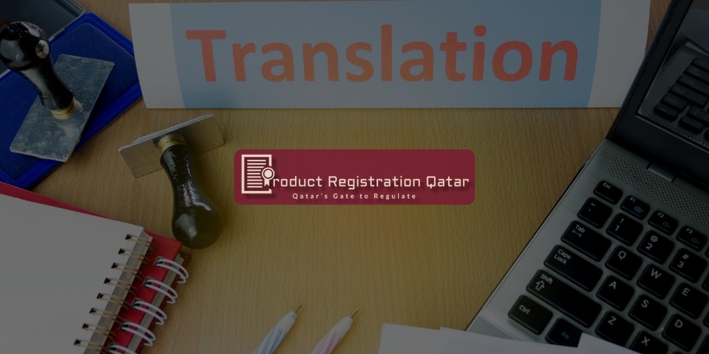 Desk with translation stamp, notebook, and a laptop beside a sign labeled "Translation" + Product Registration Qatar Logo
