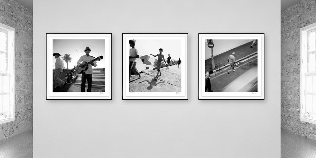 Three framed black-and-white photographs from Martin Osner’s On the Move collection displayed on a gallery wall.