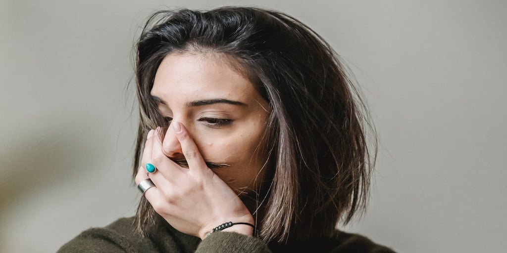 grieving woman with hand over mouth