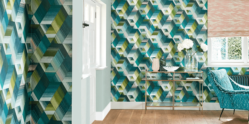 Modern living room featuring geometric teal and green patterned wallpaper with a gold console table.