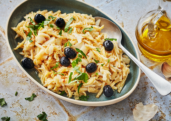 A plate of Bacalhau à Brás – traditional Portuguese codfish recipe with scrambled eggs, potatoes, an