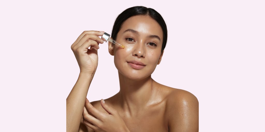 a woman applying serum on her face