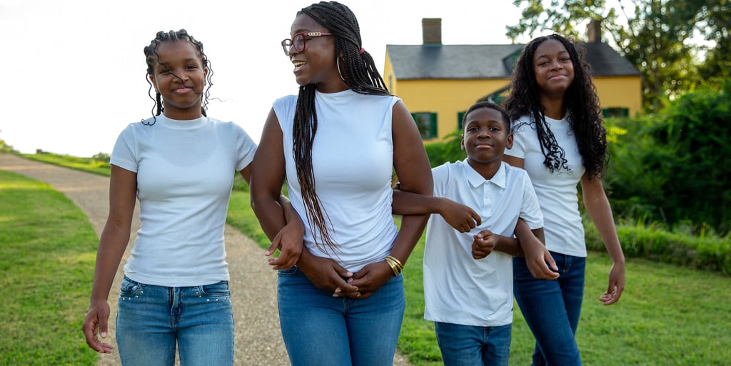 Mom with her children at a park walking arm in arm at a park during photography session