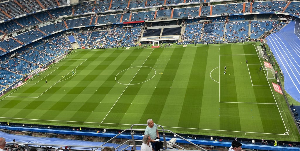 Blick ins Innere des Estadio Santiago Bernabéu in Madrid, mit tausenden Fans auf den Rängen während eines Fußballspiels.