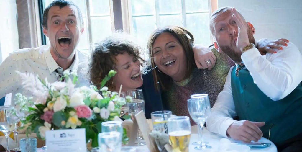 wedding guests sitting at a table havig fun