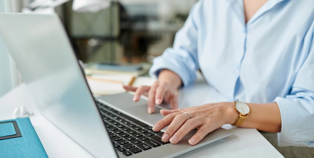 Žena u kancelariji koristi laptop za upravljanje veb sajtom i digitalnim marketingom svoje kompanije