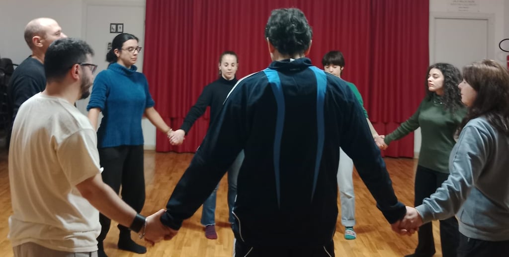 a group of people holding hands in a circle, classe di esercizi di bioenergetica