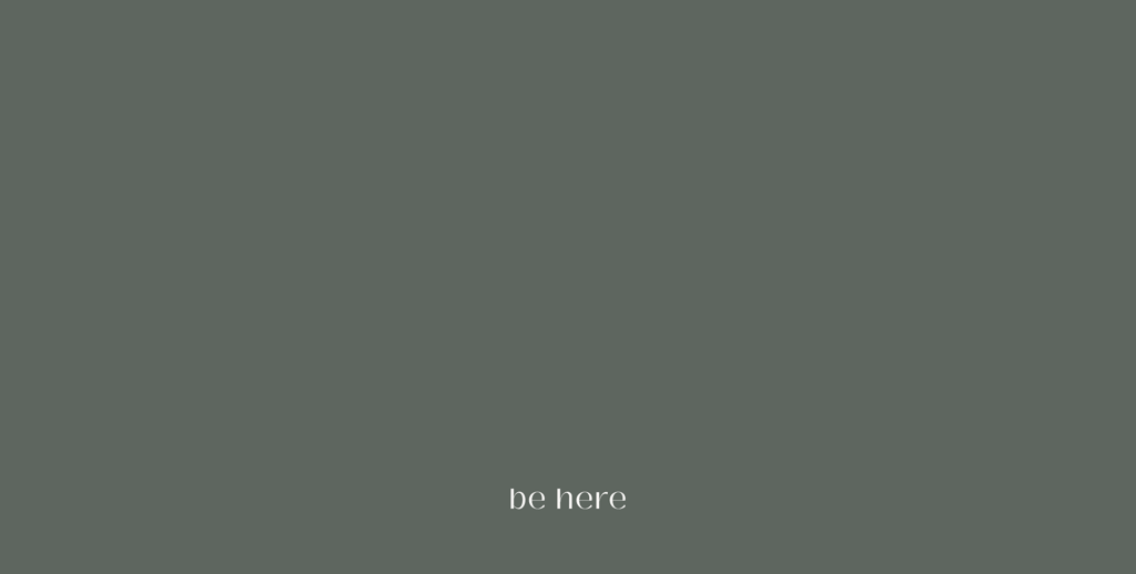 Minimalist green background with the words “be here,” symbolizing presence and stillness.