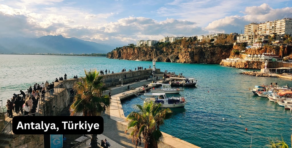 A bright, panoramic view of the Old Harbor (Kaleiçi Marina) in Antalya, Türkiye. The turquoise Medit