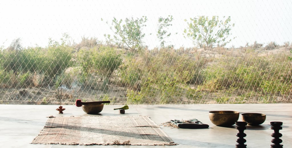 Yoga shala in afternoon sun with mat and sound bowl, symbolizing breathwork practices to reset the nervous system.