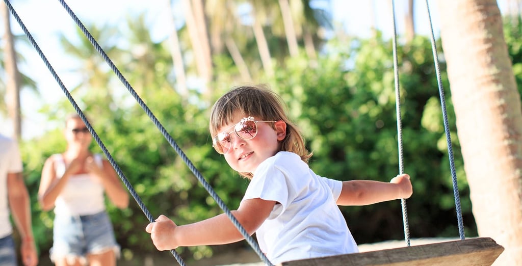 Child playing on wooden swing during Koh Samui family photoshoot