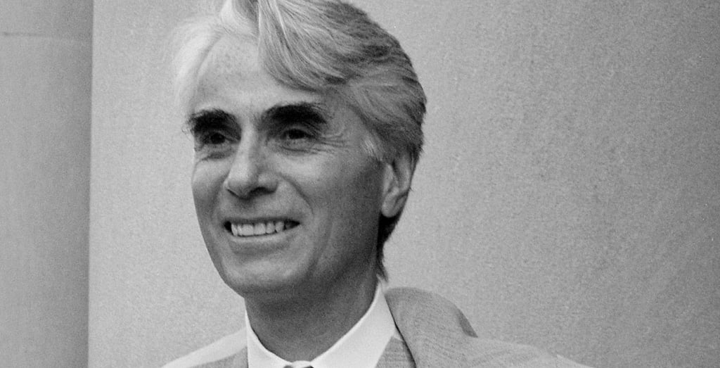 foto em preto e branco de homem grisalho branco sorrindo robert nozick