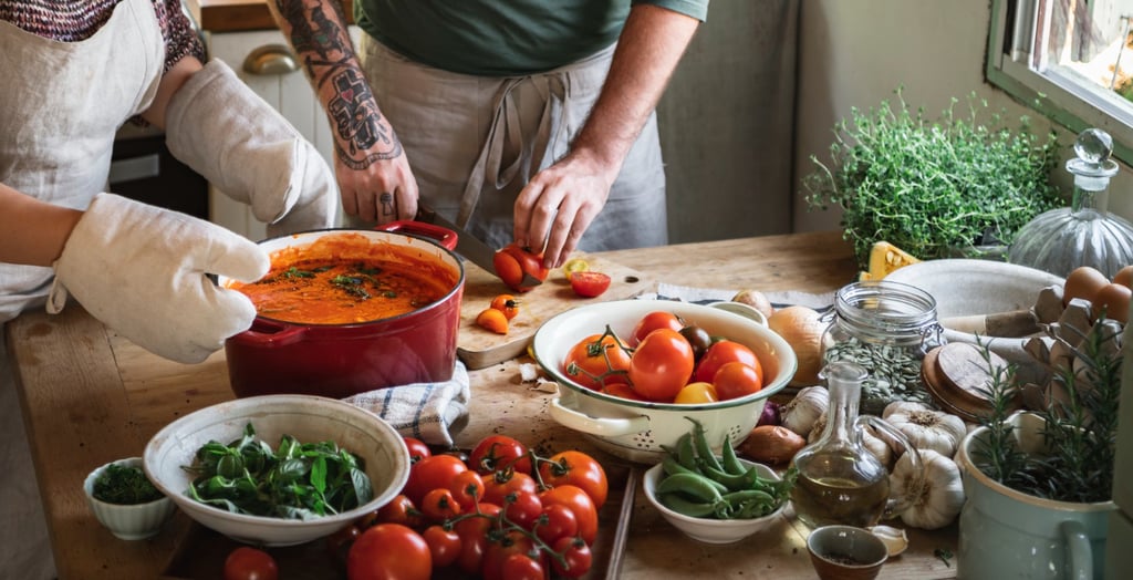 a man and woman in aprons preparing food