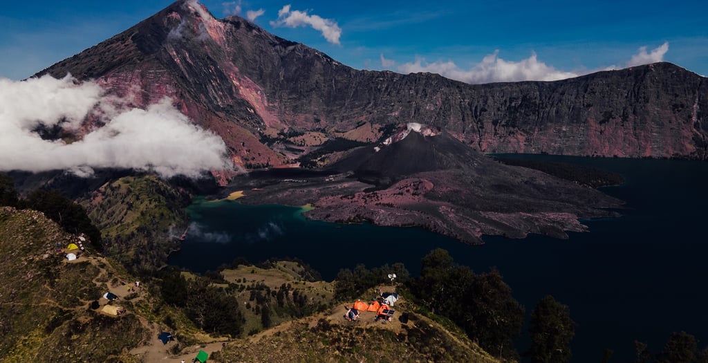 a group of people standing on a mountain top named Rinjani