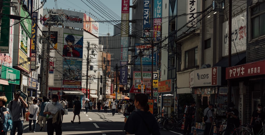 a man walking down a street with a skateboard
