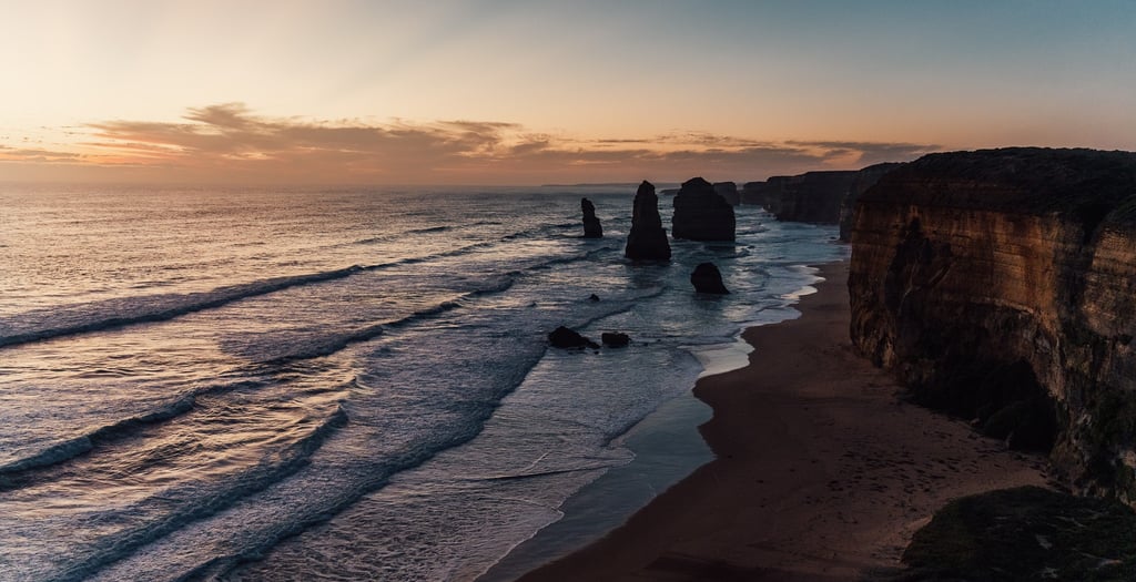 a view of the ocean and cliffs at sunset