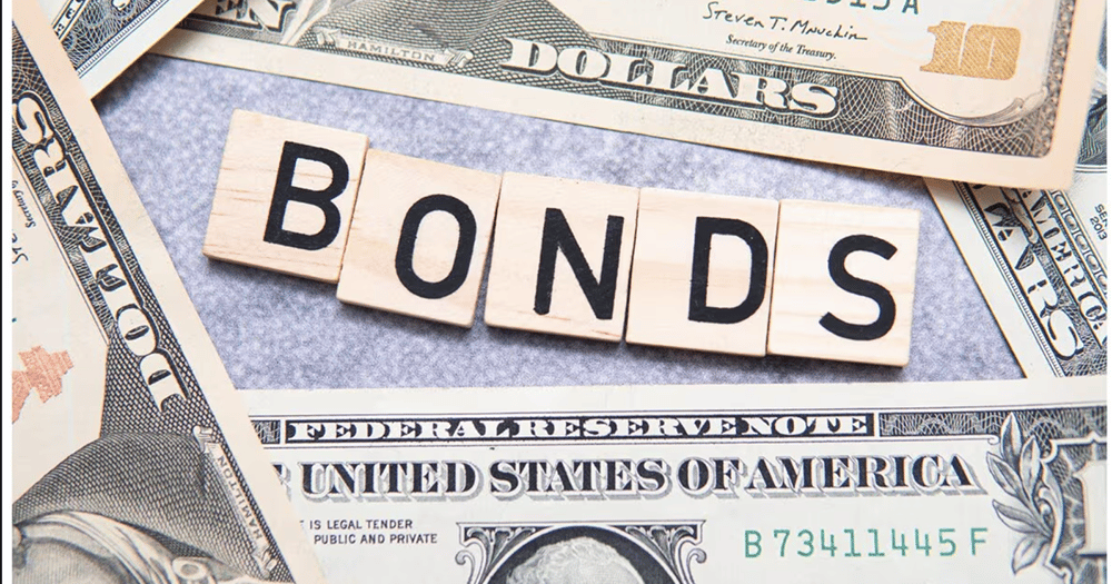 a pile of money with the word bonds spelled in wooden blocks
