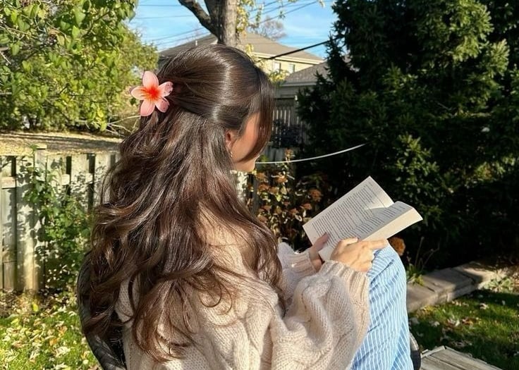 a woman sitting in a chair reading a book