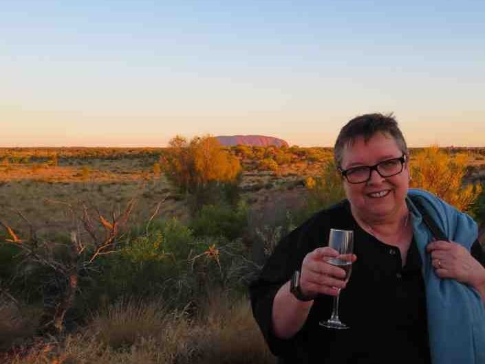 Nella at Uluru with a glass of champagne in hand