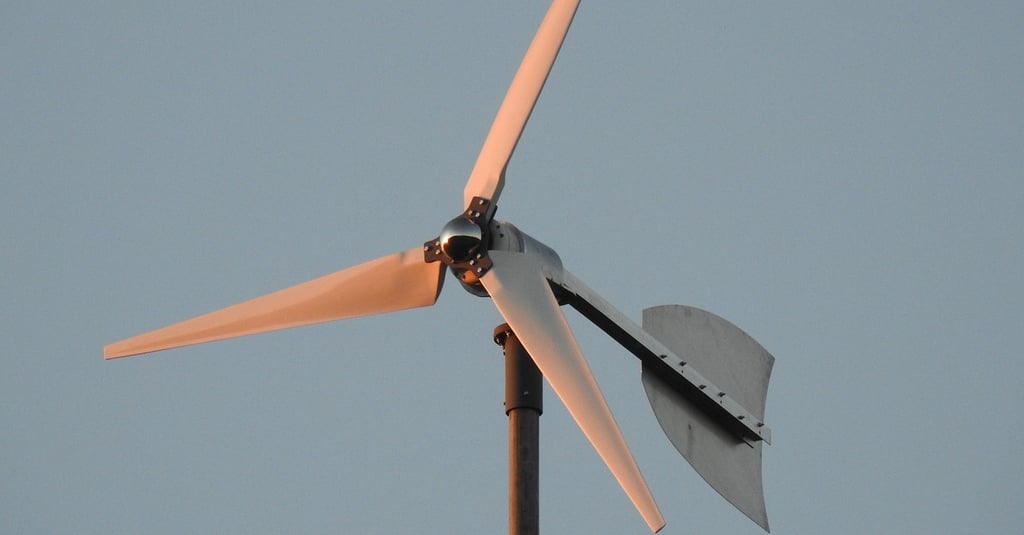 a wind turbine on a pole with a blue sky in the background