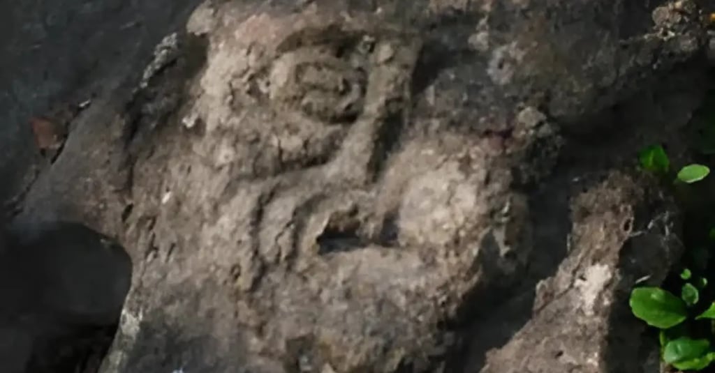 Eerie stone carving known as the Devil’s Face (Mostasù or Diaol) covered in moss along the Sentiero 