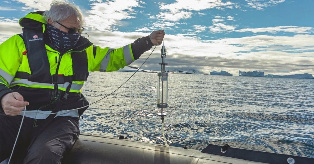 Researcher collecting ocean water samples with a Niskin bottle in Antarctica.