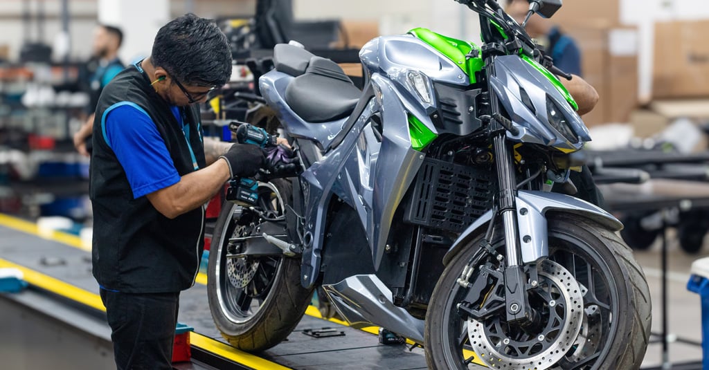 a man working on a motorcycle in a factory