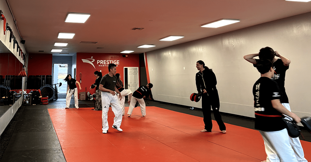 a group of people standing around a man in a karate pose