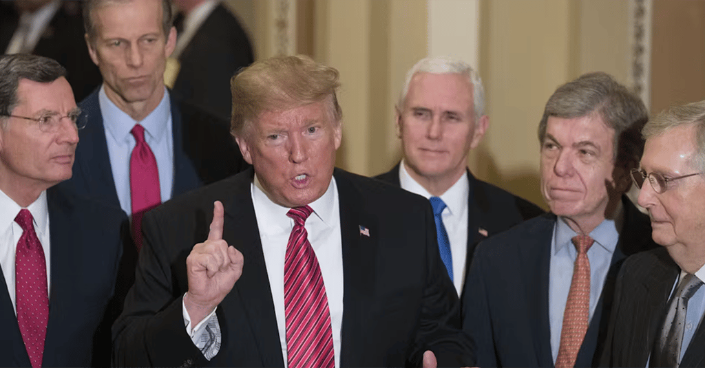 a man in a suit and tie with a finger up